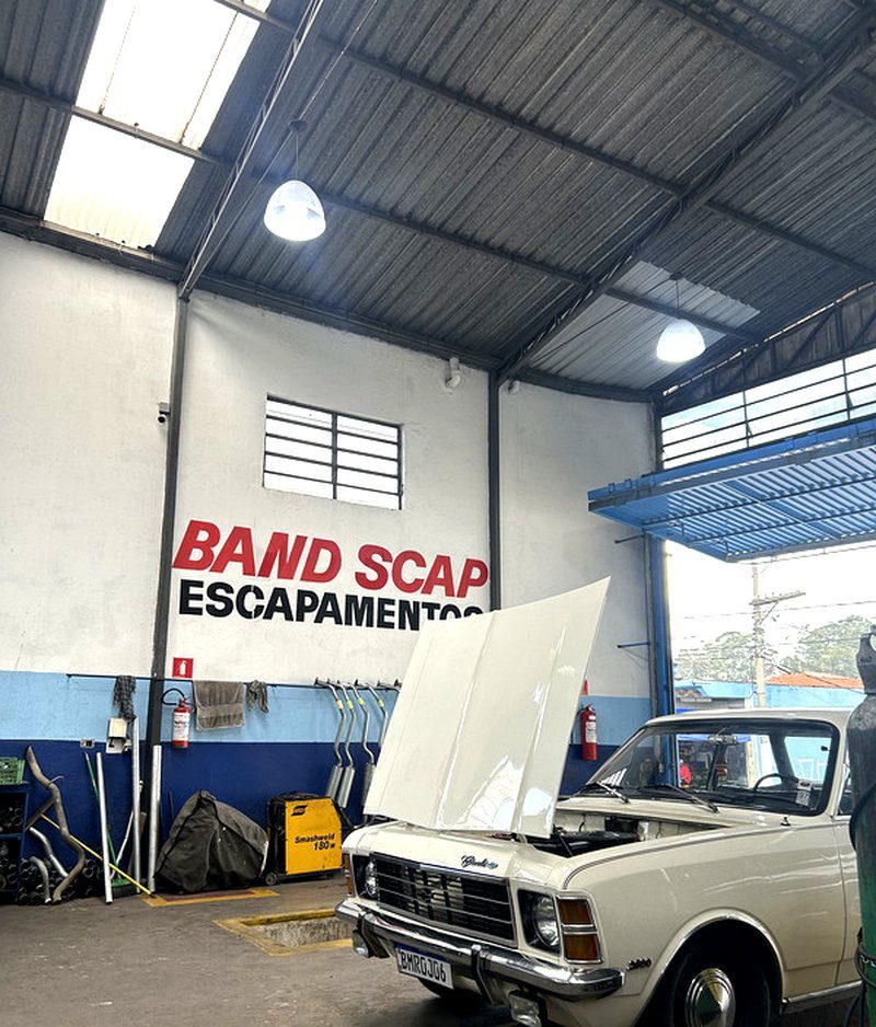 Chevrolet Veraneio branco com capô aberto em manutenção na Band Scap Escapamentos